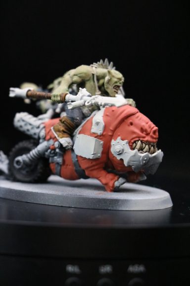 A small detailed model of a creature riding a futuristic vehicle.